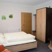 a bedroom with a bed and a wooden cabinet at Gasthof Pension Baumkirchner in Altheim