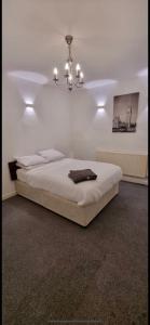 a bedroom with a large bed with a chandelier at No 2 at Mannering, Large 1 bed near Lark Lane in Liverpool