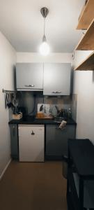 uma cozinha com armários brancos e um balcão preto em Superbe studio en plein centre ville de Rennes em Rennes