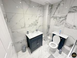 a white bathroom with a toilet and a sink at Modern 1 Bed Apartment In Morpeth Town Centre in Morpeth