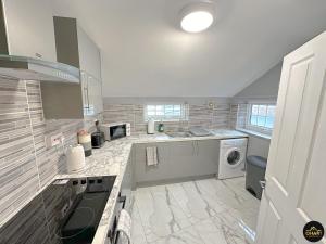 y cocina grande con fogones y lavadora. en Modern 1 Bed Apartment In Morpeth Town Centre, en Morpeth