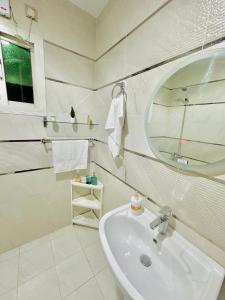 a white bathroom with a sink and a mirror at شاليه ضفاف - Difaf Chalet - فخم وجديد وفاخر in Jeddah