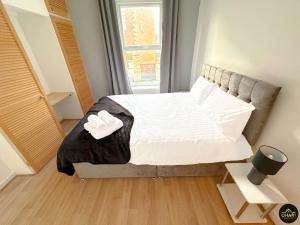 Schlafzimmer mit einem Bett mit weißer Bettwäsche und einem Fenster in der Unterkunft Modern 1 Bed Apartment In Morpeth Town Centre in Morpeth