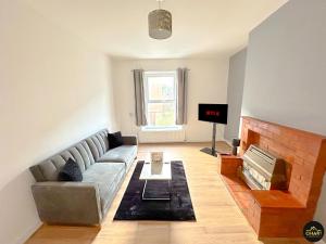 sala de estar con sofá y chimenea en Modern 1 Bed Apartment In Morpeth Town Centre, en Morpeth