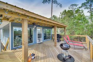 una casa con terraza con parrilla y banco en Bay St Louis Home with Private Dock and Kayaks!, en Shoreline Park