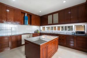 a large kitchen with wooden cabinets and a counter top at Phuket Private Pool and Thai Villa Style by Andaman Home in Phuket Town