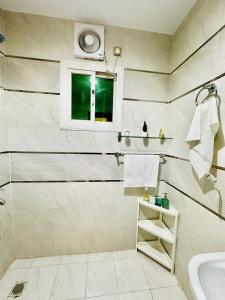 a bathroom with a sink and a window at شاليه ضفاف - Difaf Chalet - فخم وجديد وفاخر in Jeddah