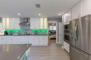 a kitchen with white cabinets and a stainless steel refrigerator at 5BR Wellington Equestrian Retreat in Wellington