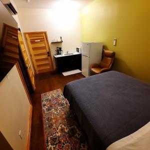 een kleine kamer met een bed en een keuken bij Goldfinch Suites in Elkader