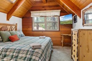 a bedroom with a bed and a window in a cabin at Knoll Lake Cabin in Big Bear Lake in Big Bear Lake