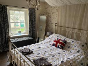 Schlafzimmer mit einem Bett und einem Fenster in der Unterkunft Lavender Cottage, Grade 2 Listed Period Stone Built Cottage In Pickering, North Yorkshire in Pickering