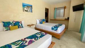 1 dormitorio con 2 camas y TV de pantalla plana en Azul Maria Bacalar, en Bacalar