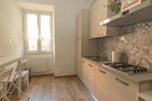 cocina con armarios blancos y fogones en [ROME 15min]Modern Accommodation, Airport,Station,LinkHouseCiampino en Ciampino