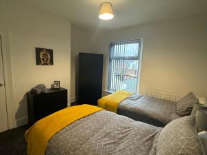a bedroom with two beds and a window at Stunning 4 bedroom 8 person 2 bathroom house! in Hull