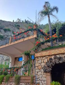 a building with a balcony with flowers on it at Hotel Corallo in Taormina