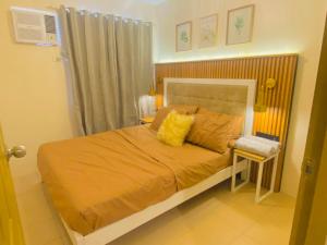 - une chambre avec un lit doté de draps orange et d'oreillers jaunes dans l'établissement 4108 Davao City 2bedroom unit 8 Spatial Maa by Filinvest, à Davao