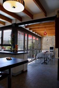 cocina y comedor con mesa y algunas ventanas en La Llar D'aitana, en Alcoleja