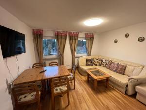 ein Wohnzimmer mit einem Sofa und einem Tisch in der Unterkunft Ferienhaus Frei 1 Hinterzarten in Hinterzarten