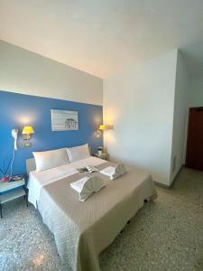 1 dormitorio con 1 cama grande y pared azul en Hotel Alfa ALL INCLUSIVE 2024, en Rímini