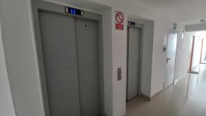 un pasillo con tres ascensores en un edificio en Moderno y acogedor cerca al mar en Lima