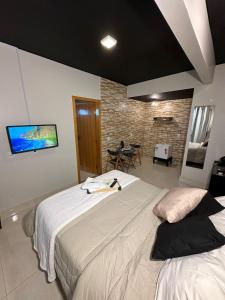 a bedroom with two beds and a tv on the wall at Hotel RIACHO in Brasilia