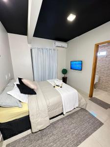 a bedroom with a large bed and a tv at Hotel RIACHO in Brasilia