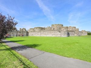 a castle with a green field in front of it at Hen Felin Isaf in Llanddona