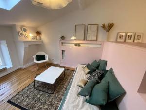 ein Wohnzimmer mit einem Sofa und einem Tisch in der Unterkunft Charmant cocon sous les toits de Bordeaux in Bordeaux