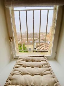 una gran ventana en una habitación con un sofá enfrente en Charmant cocon sous les toits de Bordeaux, en Burdeos