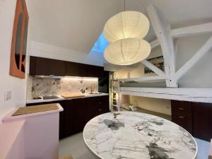 a kitchen with a table and two lights in it at Charmant cocon sous les toits de Bordeaux in Bordeaux