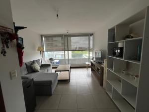 uma sala de estar com um sofá e uma janela em Buena vista y locacion em Montevidéu