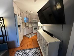 a small kitchen with a flat screen tv on a wall at Cottage in Stock Island in Key West