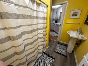 y baño con cortina de ducha y lavamanos. en Cottage in Stock Island, en Key West