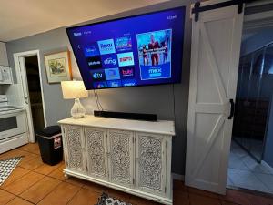 een flatscreen-tv aan een muur in een woonkamer bij Cottage in Stock Island in Key West