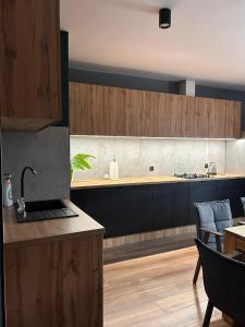 シフィエラドゥフ・ズドルイにあるIZERSKI TARAS- Górski Apartament 120m2のキッチン(木製キャビネット、テーブル、椅子付)