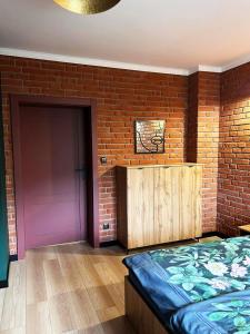 sypialnia z ceglaną ścianą i fioletowymi drzwiami w obiekcie IZERSKI TARAS- Górski Apartament 120m2 w Świeradowie Zdroju