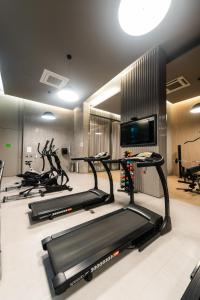 a gym with three treadmills and a flat screen tv at Rosemari's Apartments Republica in Sao Paulo