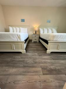 Duas camas sentadas uma ao lado da outra num quarto em Coastal Inn and Suites em Long Beach
