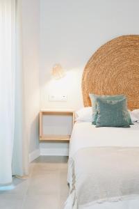 代米耶尔Apartamentos Los Flamencos的一间卧室配有一张大床和藤制床头板