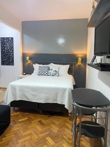 um quarto com uma cama, uma mesa e uma cadeira em Studio Copacabana no Rio de Janeiro