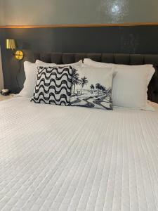 a bed with white sheets and pillows on it at Studio Copacabana in Rio de Janeiro