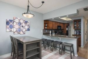 cocina con mesa, sillas y barra en 3107 The Island, en Lago Vista