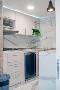 a kitchen with white marble counters and a refrigerator at Apartaestudio Vista azul rodadero Mara 502 in Santa Marta