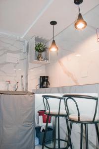 a kitchen with two bar stools at a counter at Apartaestudio Vista azul rodadero Mara 502 in Santa Marta