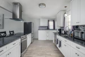 a kitchen with white cabinets and black counter tops at Eclectic Country Home in Leander
