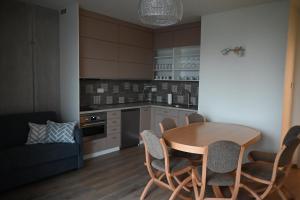 a kitchen with a table and chairs and a couch at Apartmán PERLA 28, Říčky in Říčky