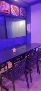a blue table with two chairs in a room with food at Hotel Shonarbangla in Calangute