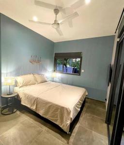 Un dormitorio con una cama grande y una ventana en Villa Fleur de Coco - 8p. - piscine privée - haut standing, en Saint-Pierre