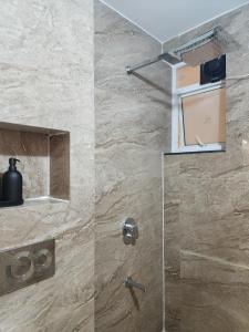 La salle de bains est pourvue d'une douche avec une porte en verre. dans l'établissement MYKA SD ZANITA HEIGHTS, à Vasco Da Gama