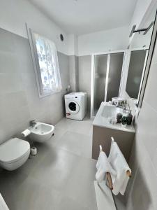 bagno bianco con servizi igienici e lavandino di Casa vacanze Sofy & Marty a Cattolica